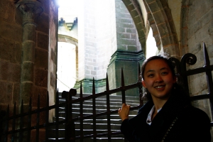 La bailarina de Shen Yun Jade Zhan a la entrada de la abad&iacute;a y la catedral de St. Michel (Annie Li).