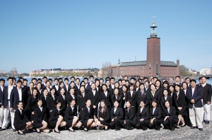 La Touring Company prend la pose pour une photo de groupe devant le port et l&rsquo;h&ocirc;tel de ville de Stockholm.