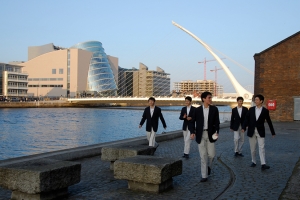 Bailarines caminando a orillas del r&iacute;o Liffey, frente al teatro de Dubl&iacute;n.