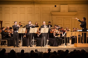 From left: Kaspar Martig, Eric Robins, and Alexander Wilson perform Leroy Anderson&#039;s &#039;Bugler&rsquo;s Holiday,&#039; conducted by Yohei Sato.