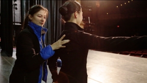 La prima ballerina Madeline Lobjois aiuta un’altra ballerina in un movimento di danza al Boston Opera house
