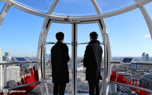 Tymczasem, w Londynie, członkowie orkiestry Shen Yun International Company odwiedzili London Eye. Puzonista Tianli Hong (po lewej) i skrzypek Joshua Lin patrzą w kierunku wschodu. (fot. Darrell Wang)
