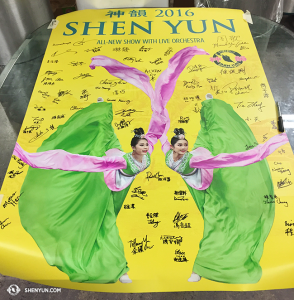 2016 poster ditandatangani oleh anggota Shen Yun International Company.