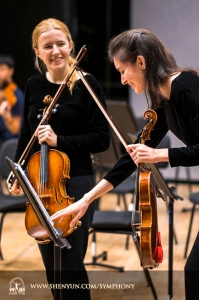 První houslistka Paulina Mazurkiewicz a houslistka Elisabeth Reynolds uvolňují atmosféru před koncertem.
