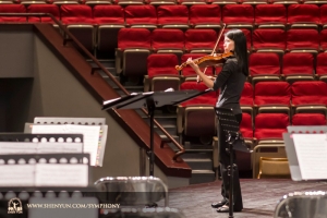 Houslová sólistka Fiona Zheng se připravuje na skladbu Introdukce a Rondo Capriccioso od  Camille Saint-Saënse v tchajwanském Hsinchu Culture Bureau Performance Hall.