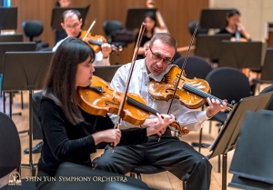Pemain violin utama Vardan Petrosyan (kanan) dan asisten violist utama Rachel Chen meninjau ulang bagian repertoar tersebut. (Foto oleh TK Kuo)