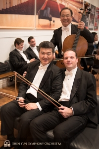 Principal bassist Juraj Kukan (R) and bassist Wei Liu wait to be reunited with their instruments on stage—cellist James Zheng doesn't need to wait.
