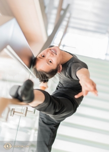 Angelia Wang, originally from Chicago, uses the railing of the theater's glass staircase as a barre to warmup!
