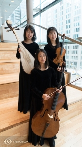 Het Shen Yun Symfonie Orkest combineert naadloos zowel Chinese als Westerse instrumenten. Hier kunt u het Chinese instrument de pipa zien (bovenaan links) samen met zijn westerse vrienden de viool en cello. Yuru Chen, Rachel Chen, en Yuchien Yuan (van bovenaan links met de klok mee) zijn verheugd om in het Four Seasons Centre in Toronto te zijn. (Foto door percussioniste Tiffany Yu)
