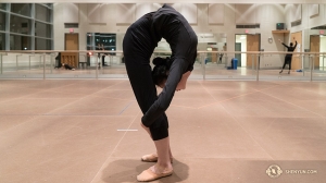 Danseres Karina Fu warmt zich op door zichzelf dubbel te vouwen. (Foto door percussioniste Tiffany Yu)
