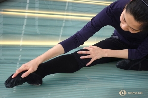 Nach einigen Besichtigungen ist es an der Zeit, sich zu dehnen. Die Erste Tänzerin Linjie Huang achtet dabei besonders auf ihre Zehen. (Foto: Annie Li, Bühnenrojektion)
