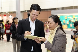 Emcee Ben Freed signs an autograph.