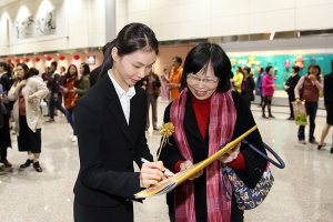 Solistdansaren Jaling Chen skriver en autograf. 
