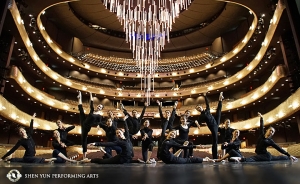 The Shen Yun World Company poses in the Winspear Opera House in Dallas, Texas. The theater was designed as a 21st-century version of a traditional opera house. The theater's enormous retractable chandelier hangs in the background.
