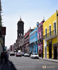 The bold and vibrant painted buildings stand out next to the more subtle brick church in the background. (Photo by dancer Edwin Fu)
