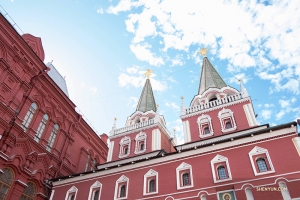 Red paint and the golden-tipped spires atop the Kremlin are striking against the blue sky.
