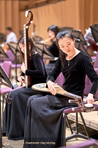 Hráčka na pipu, Miao-Tzu Chiu, ladí svůj nástroj po výměně struny.