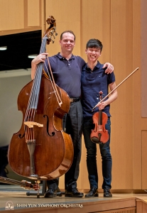 Eerste bassist Juraj Kukan en violist Austin Zhong poseren vrolijk voor de camera.
