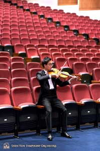 Violist Jeff Lai warmt op tussen de stoelen in de zaal van Taoyuan’s Zhongli Arts Hall.
