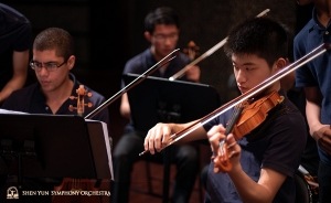 Violinists and stand buddies Gustavo Briceño and Zhengnian Song prepare for rehearsal.
