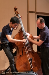 Contrabassist TK Kuo (l) en eerste contrabassist Juraj Kukan inspecteren Kuo’s contrabas.
