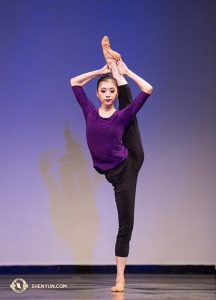 Soutěžící Jane Chen předvádí postranní držení nohy s perfektní stabilitou.
