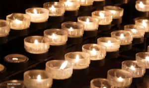 Des rangées de bougies de prière illuminent la cathédrale. (Photo de Tiffany Yu)<br />