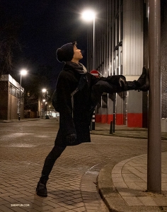 È vero: i ballerini fanno stretching dappertutto. Roy Chen fa una pausa durante una passeggiata serale a Rotterdam (foto di Nick Zhao).
