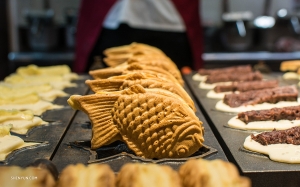 Ce magasin de taiyaki à Tokyo propose une gamme de saveurs allant du camembert (G) au haricot rouge le plus répandu !<br />
