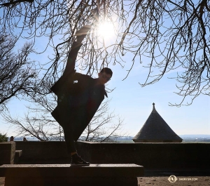 Penari Scott Xu menendang ke arah matahari. (Foto oleh Nick Zhao)