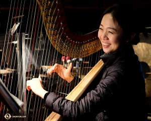 Harpist Crystal He melakukan pemanasan di lubang orkestra Ordway Center. (Foto oleh Karen Chen)