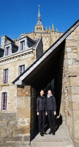 Les danseuses Jaling et Madeline Lobjois posent avec le point culminant de l'île : le clocher de l'abbaye, à l'arrière-plan. (Photo de Kexin Li)<br />
