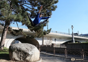 A dancer leaps from a rock in Geneva—fingers crossed for a soft landing! (Photo by Nick Zhao)