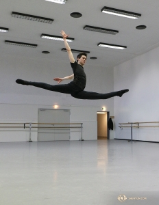 W teatrze, w sali przeznaczonej do ćwiczeń, tancerz Peter Kruger rozgrzewa się, wykonując wyskoki ze szpagatem. (Photo by Nick Zhao)
