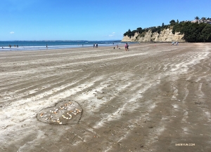 Tancerka Betty Wang zostawia swój ślad na plaży w Long Bay Regional Park w Auckland, Nowa Zelandia.
