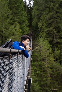 Built in 1889, Capilano Suspension Bridge stretches 450 feet (137m) across and 230 feet (70m) above Capilano River. Principal Dancer William Li enjoys the elevated view. (Photo by Sam Pu)
