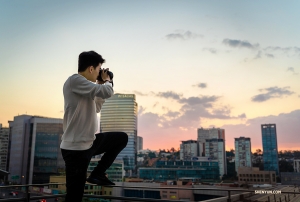 <p>L'artiste en action : le premier danseur William Li tente de photographier le coucher de soleil depuis son balcon. (Photo du danseur Daniel Jiang) </p>
