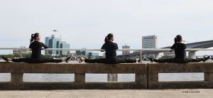 Dancers (left to right) Kaidi Wu, Eva Su, and Cecilia Wang find comfy seats to watch the boats go by. (Photo by Diana Teng)