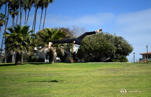 Taking advantage of the open space at Dana Point Harbor, Principal Dancer Elsie Shi performs a flip in the field. (Photo by Annie Li)
