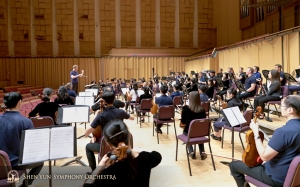 Orchestr dále odcestoval na jih do Pching-Tungu. Pohled na zkoušku zpoza sekce hráčů na violoncello.