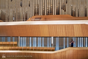 Violist Max Zhong, silhouetted in front of the largest pipe organ in Asia, at the National Kaohsiung Center for the Arts.