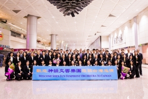 Welkom in Taiwan! Het Shen Yun Symfonie Orkest poseert voor een groepsfoto op de luchthaven voordat ze in de bus stappen.