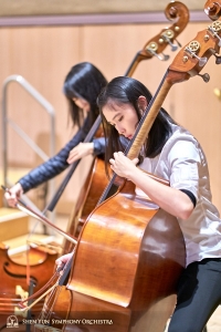 Para pemain bass Juexiao Zhang (kiri) dan Chloe Chang sedang bersiap untuk pertunjukan Shen Yun Symphony Orchestra di Roy Thompson Hall, Toronto.