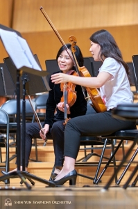 Concertmaster Chia-Chi Lin mendiskusikan sebuah bagian lagu bersama pemain utama biola Rachel Chen di Hsinchu Performing Arts Center.