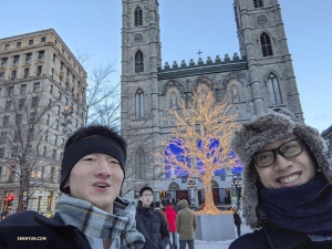 Ben Chen prenant un selfie de lui, de son collègue danseur Jun Liang et d’un arbre richement illuminé.