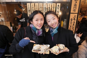 Les premières danseuses Angelia Wang (à gauche) et Melody Qin dégustent une spécialité locale de coquillages.