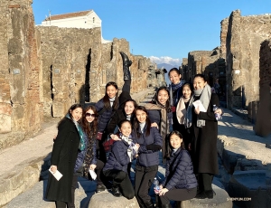 Sorrisi illuminati dal sole sui gradini di una strada di Pompei, un grande sito archeologico vicino al Golfo di Napoli.