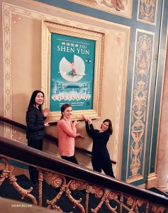 In the lobby of the timeless Detroit Opera House we have (from left) cellist Jasmine Jordan, violist Paulina Mazurkiewicz, and oboist Leen De Blauwe next to an exquisitely framed Shen Yun poster. (Photo by Leeshai Lemish)