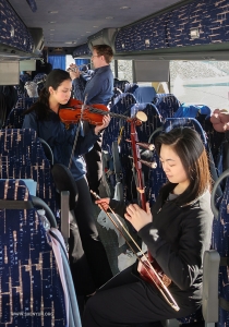 Terwijl de dansers buiten de benen strekken, maken onze musici van de gelegenheid gebruik om een oefensessie in te lassen in de bus.