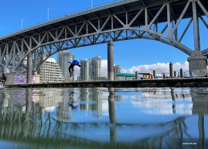 Dancer Hubert Qu flips like a dolphin on the shore of False Creek, in the heart of Vancouver. 